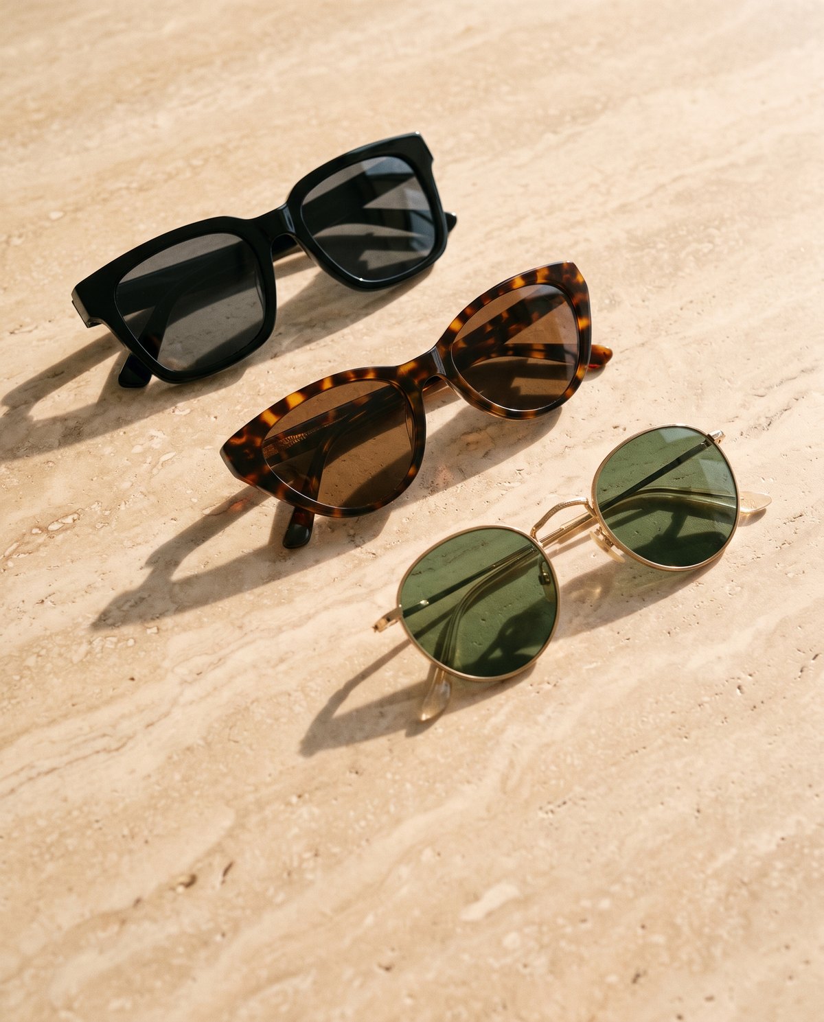 Three Retinosa sunglasses styles in afternoon light on travertine